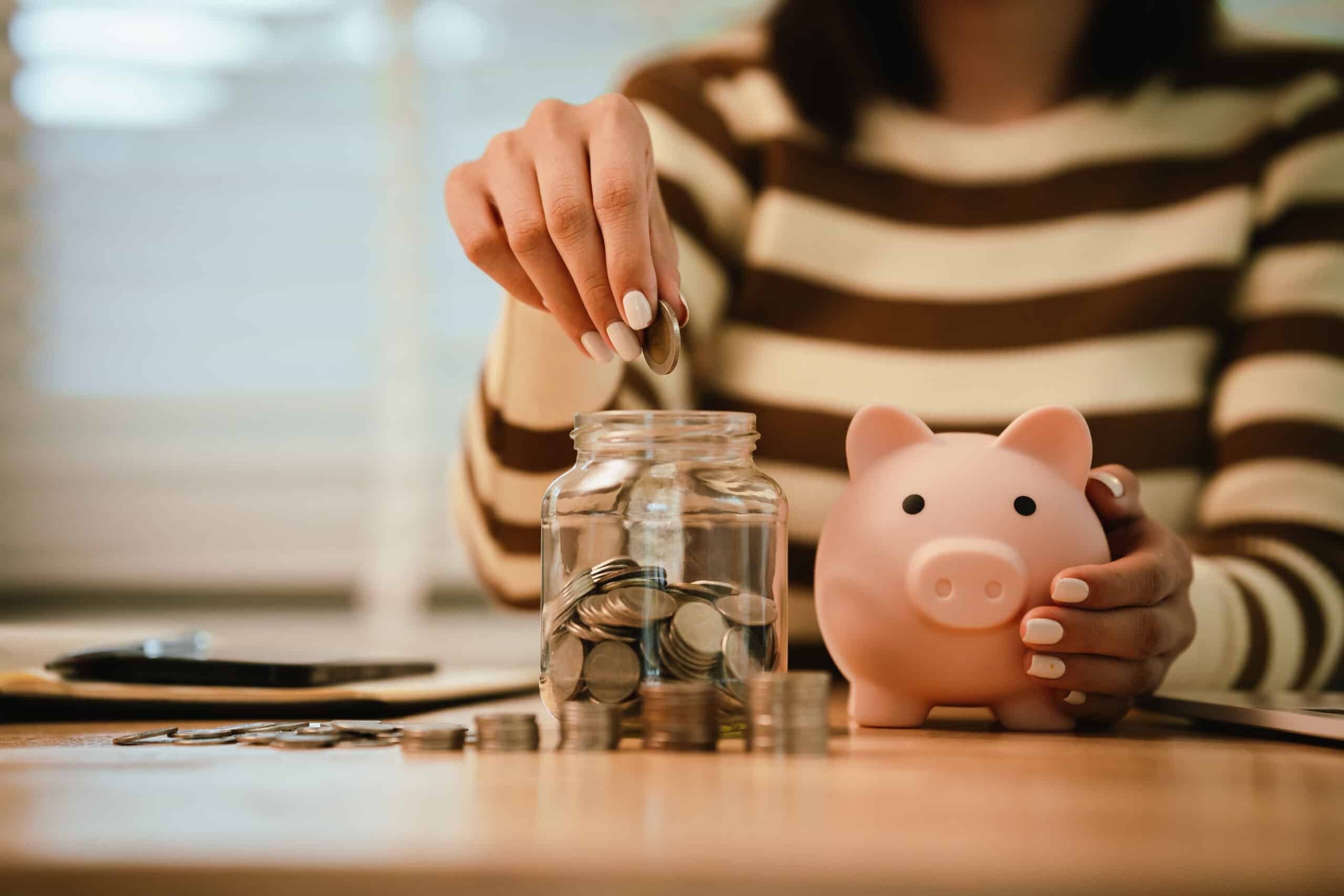 Ten ways to maximize your savings in 2026, A woman holds a piggy bank, which symbolizes savings, financial planning, and economic challenges. Budgeting, investing, and money management for a secure future.