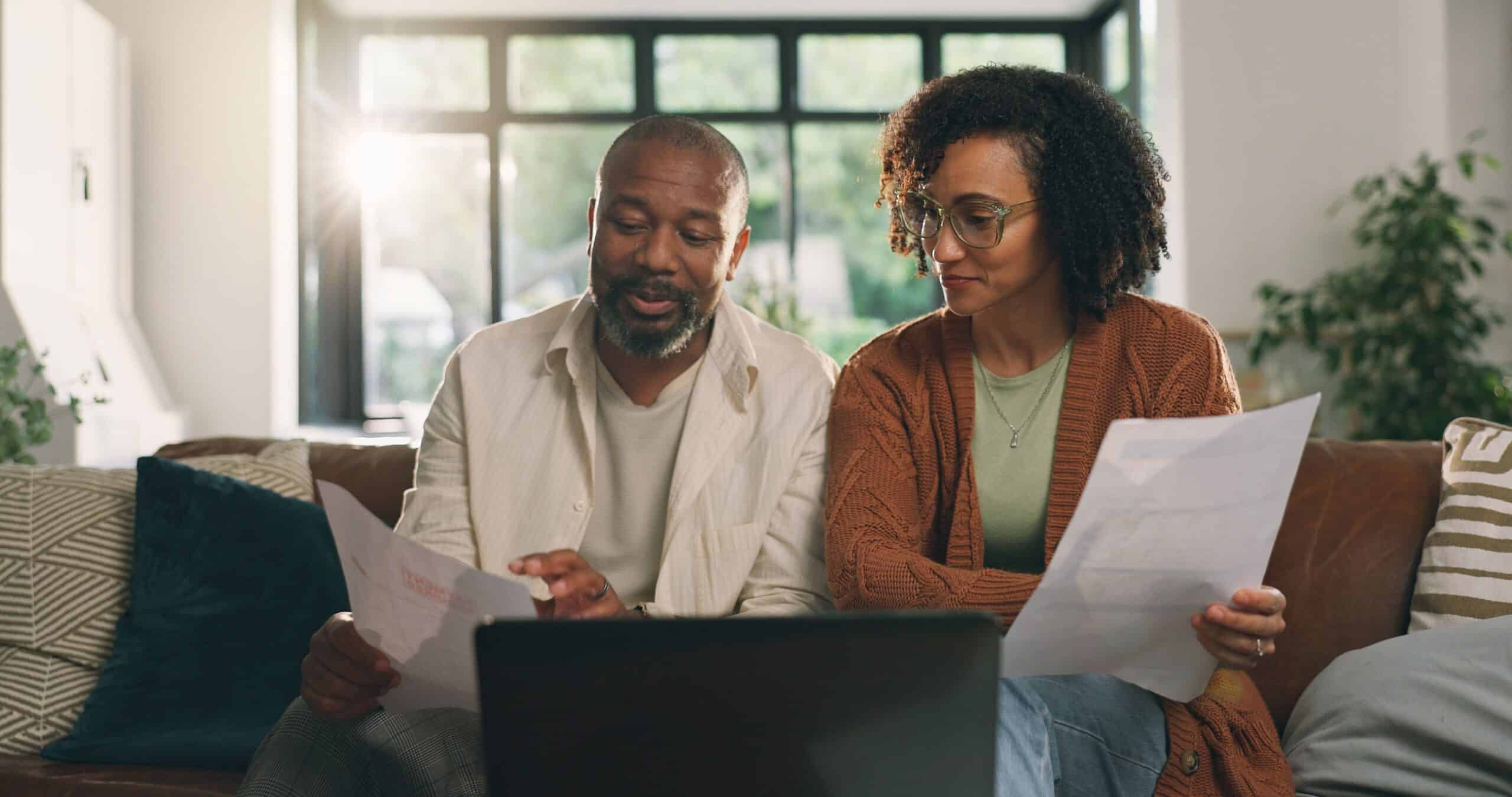 Couple reviewing financial documents, mortgage refinance, when to refinance, mortgage refi, reasons to refinance, couple reviewing mortgage documents, when should you refinance your mortgage
